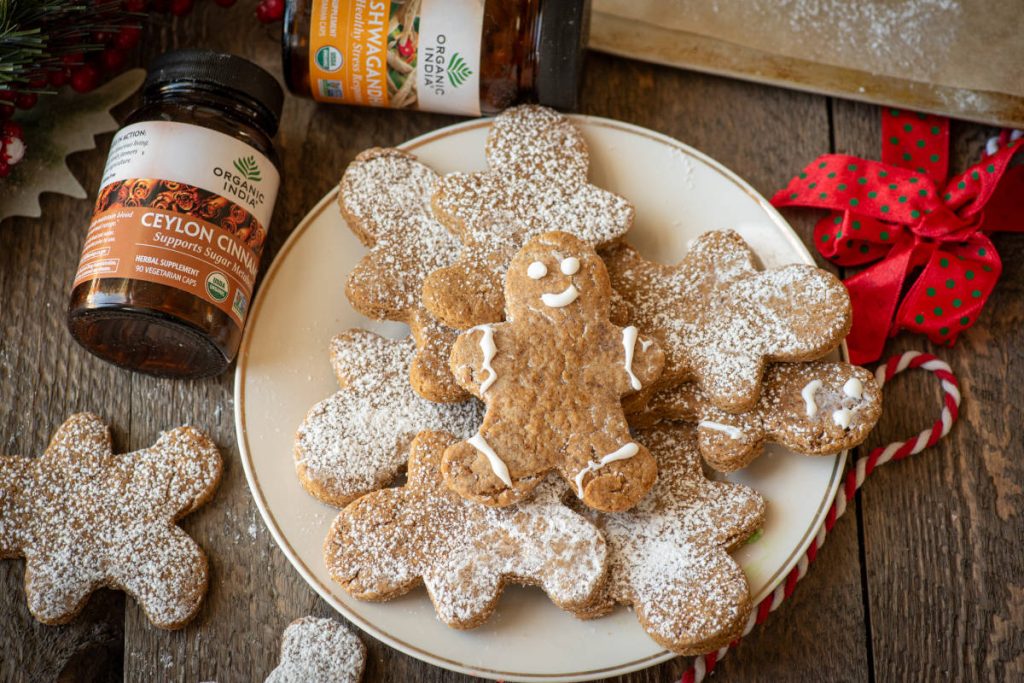 Gingerbread cookies with aswagandha recipes, cute gingerbread men decorated with powdered sugar on a white plate.