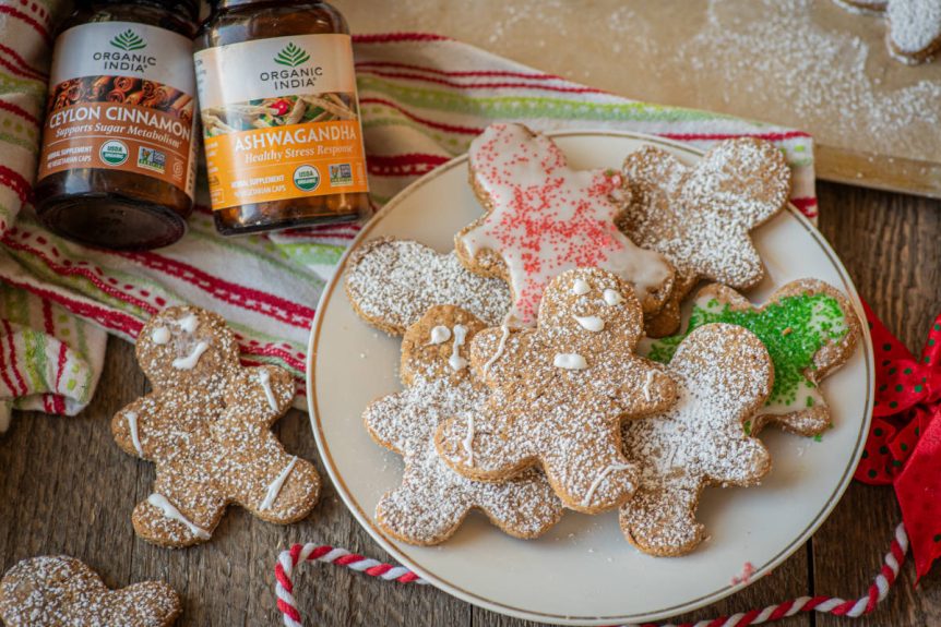 Gingerbread cookies with aswagandha recipes, cute gingerbread men decorated with icing on a white plate.