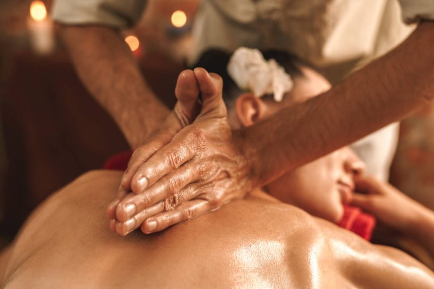 Person receiving an abhyanga massage, or oil massage by candlelight