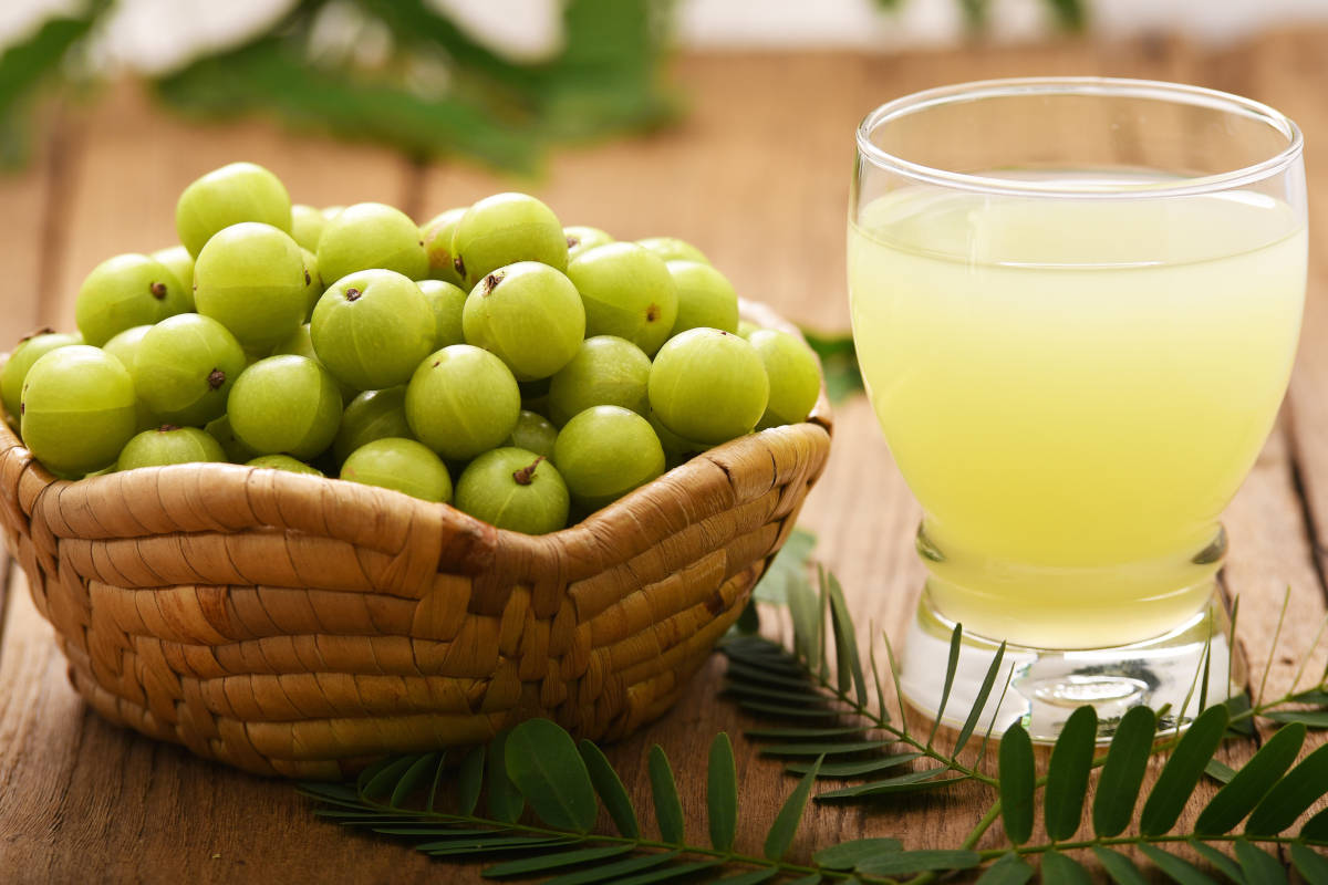 amla powder benefits in water glass on wood table