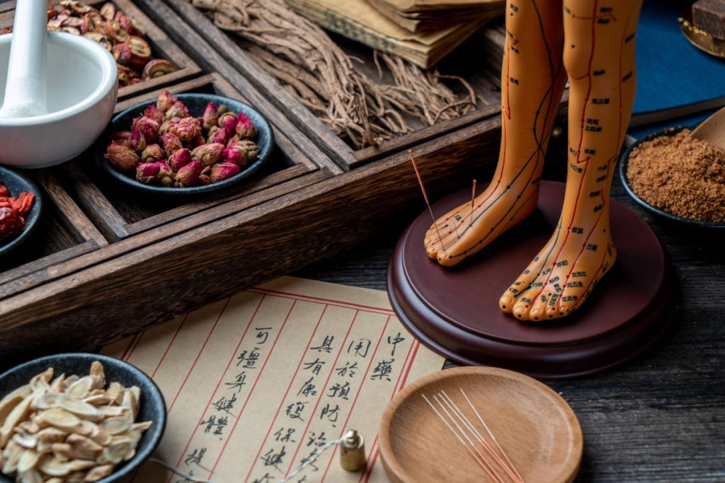 Ashwagandha in tcm on a desk with traditional chinese medicine tools and herbs