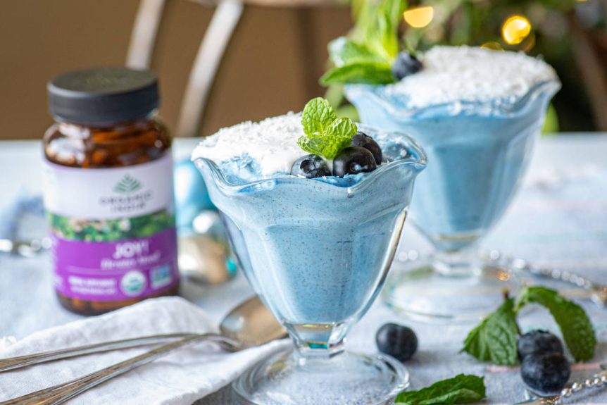 Blue majik mousse in a dessert glass with blueberry and mint garnish.