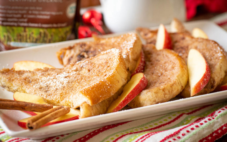 Cinnamon French Toast with apples and pears on a white plate with red, white and green place mat