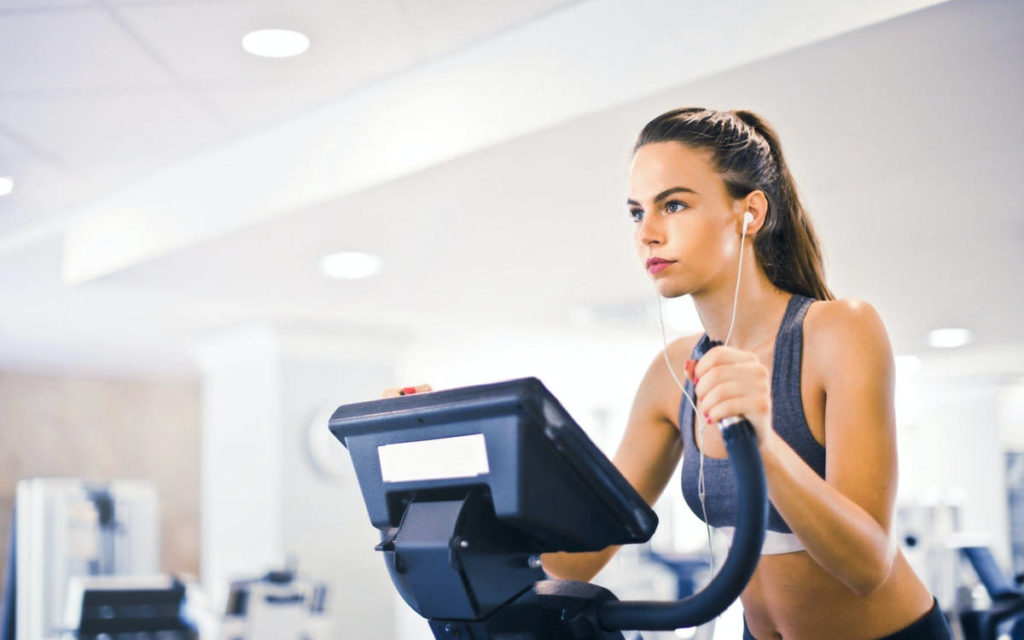 Woman on an elliptical exercising to support her adaptive and innate immune systems.