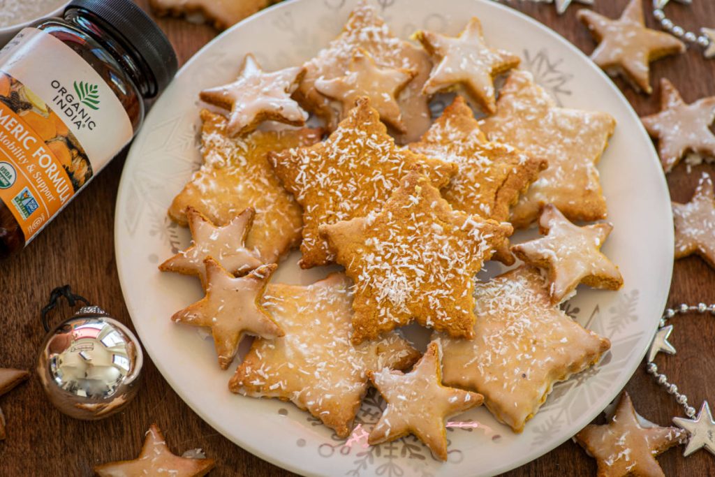 Golden milk cookies with turmeric on a white plate shaped like stars.