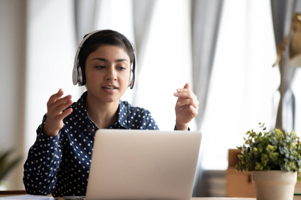 Woman working productively on her laptop with headset using gotu kola for brain health.