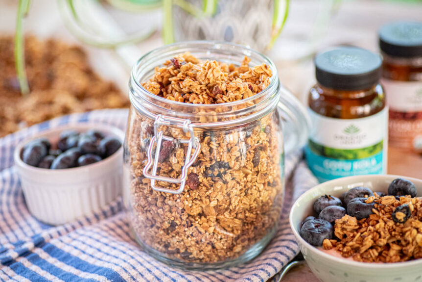 Gotu kola granola in a clear jar and bowl with blueberries.