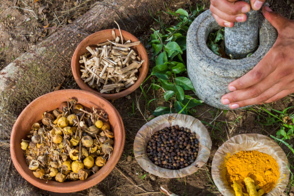 Man grinding spices and herbs for hormonal balance with a mortar and pestle. 