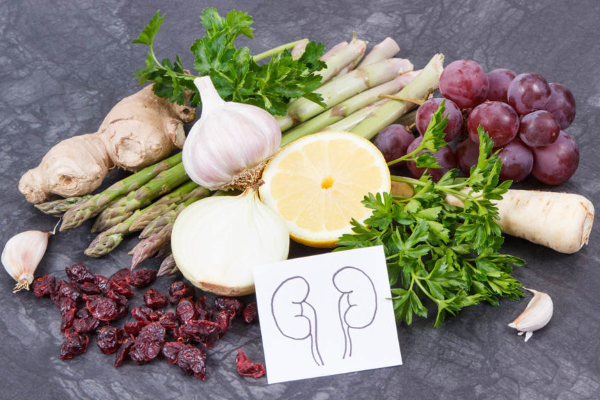 Table with foods and herbs for kidney health, like cranberry, ginger, celery and more.