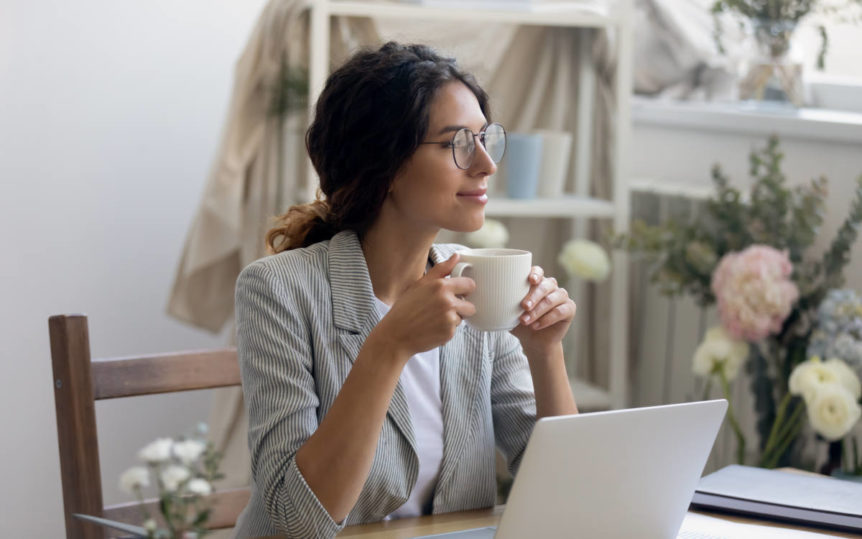 Woman with glasses drinking tea with herbs to support mental clarity.