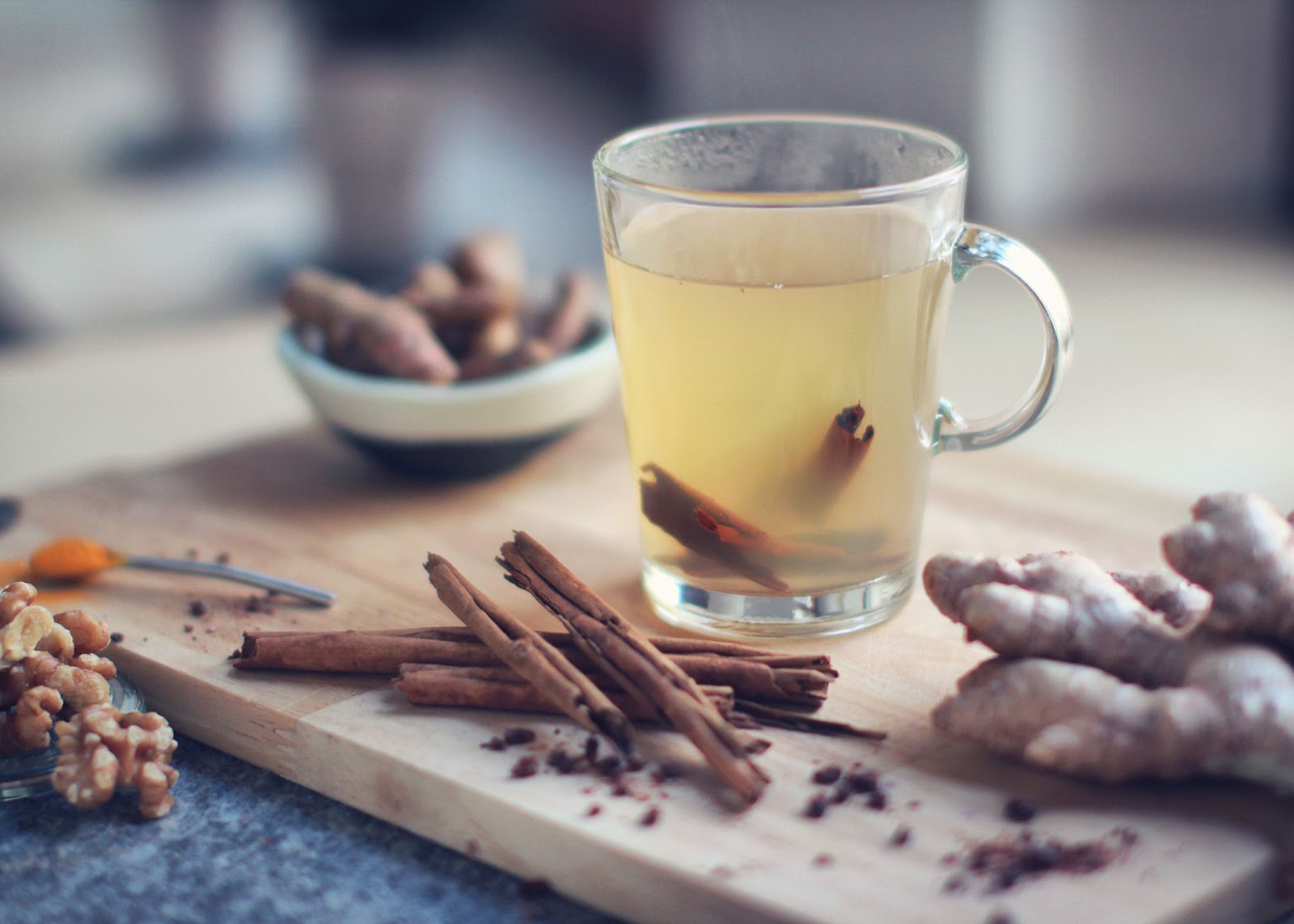 Tea with cinnamon and ginger for lung health in a clear cup on a cutting board.