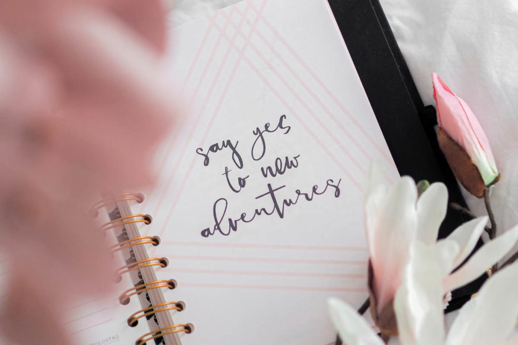 Intention written in a journal that reads "say yes to new adventures."