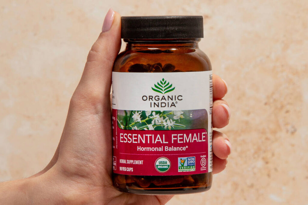 Essential Female capsules held in a woman's hand, with lodhra for women benefits.