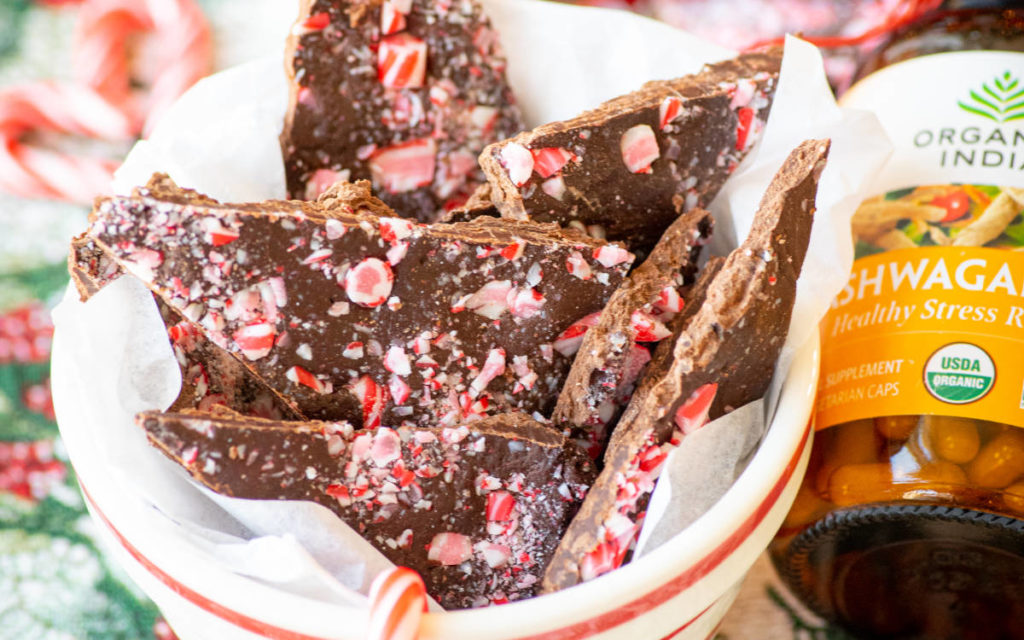 Peppermint bark made with chocolate and candy canes in a red and white cup. 