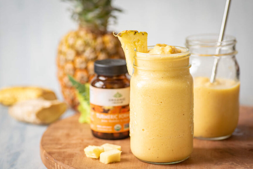 Pina Colada smoothie in a clear drinking jar with pineapple and banana