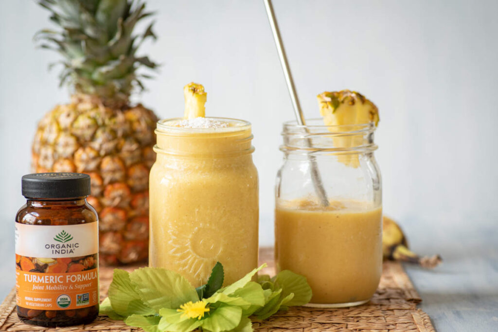 PIna Colada Smoothie in mason jars with pineapple and turmeric formula supplement. 