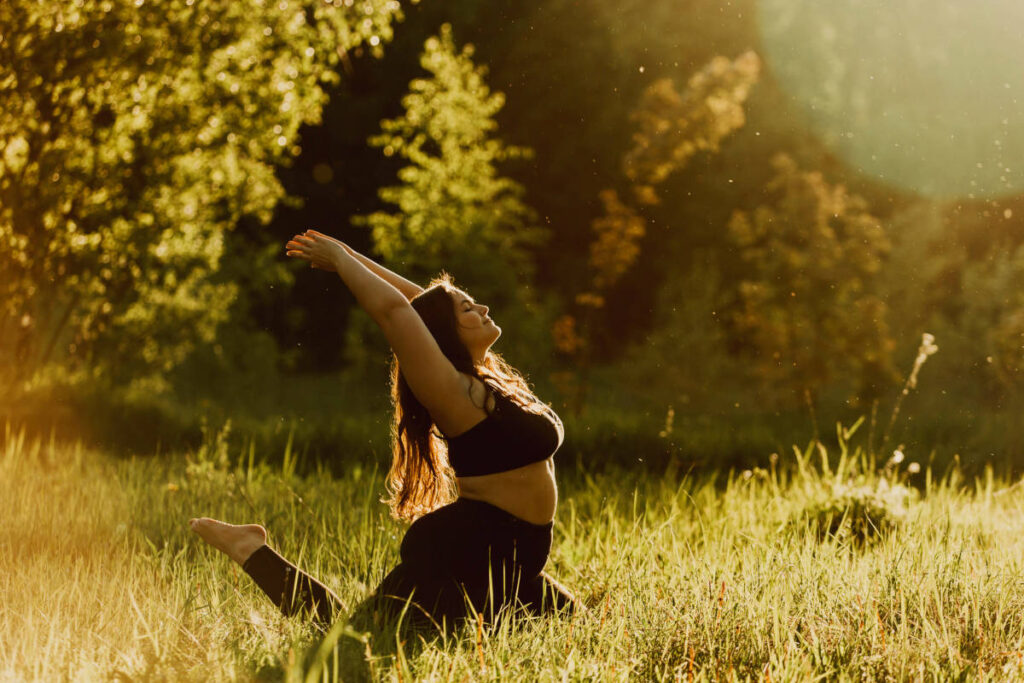 Woman practicing self nurturing by doing yoga outside in nature.