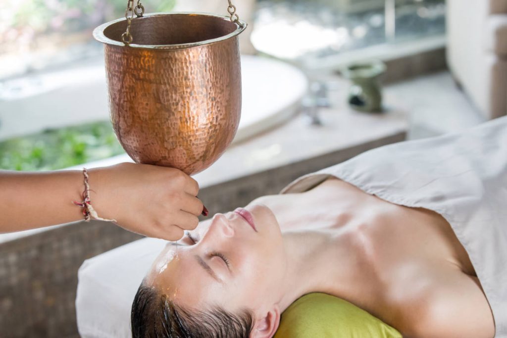 Person receiving shiro abhyanga or shirodara treatment, an oil massage for the head.