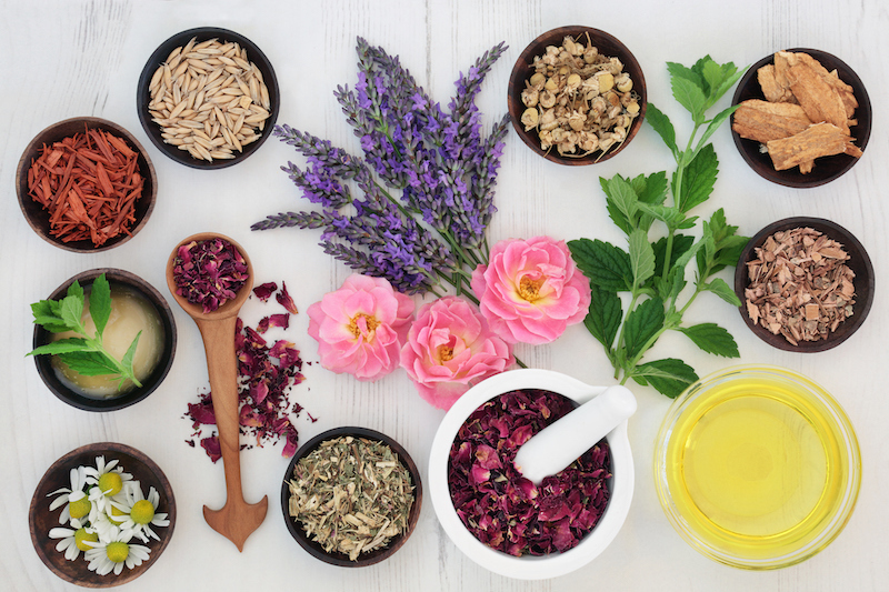 Herbs, flowers and spices on a white table for Ayurvedic Skincare.