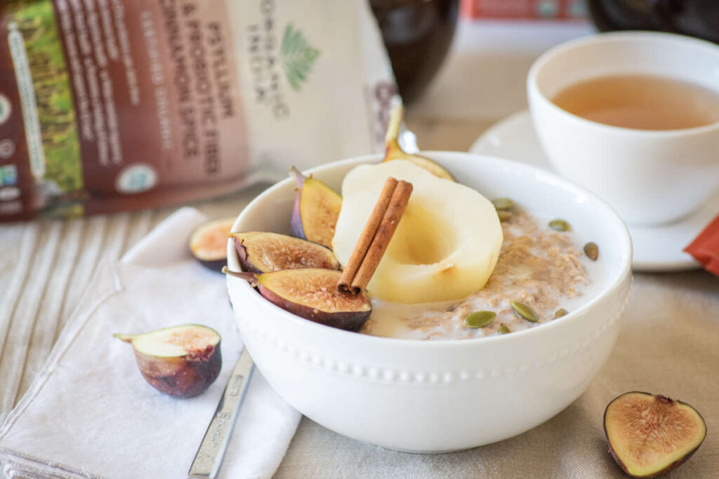 Autumn spiced psyllium oatmeal with poached pear and cinnamon stick garnish