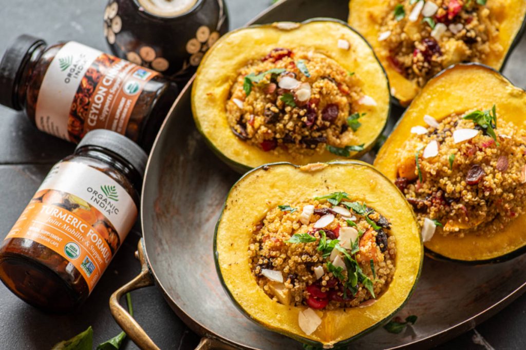 Stuffed acorn squash with a spiced quinoa cranberry stuffing in a copper serving dish