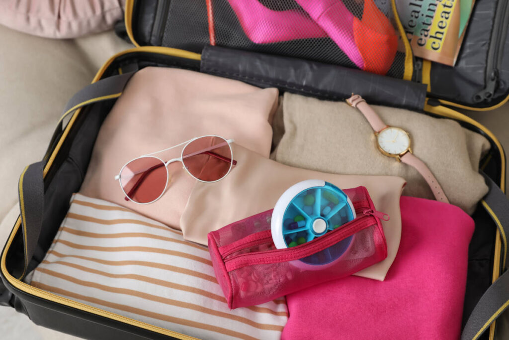 Carryon suitcase with sunglasses, clothes, watch and supplements
