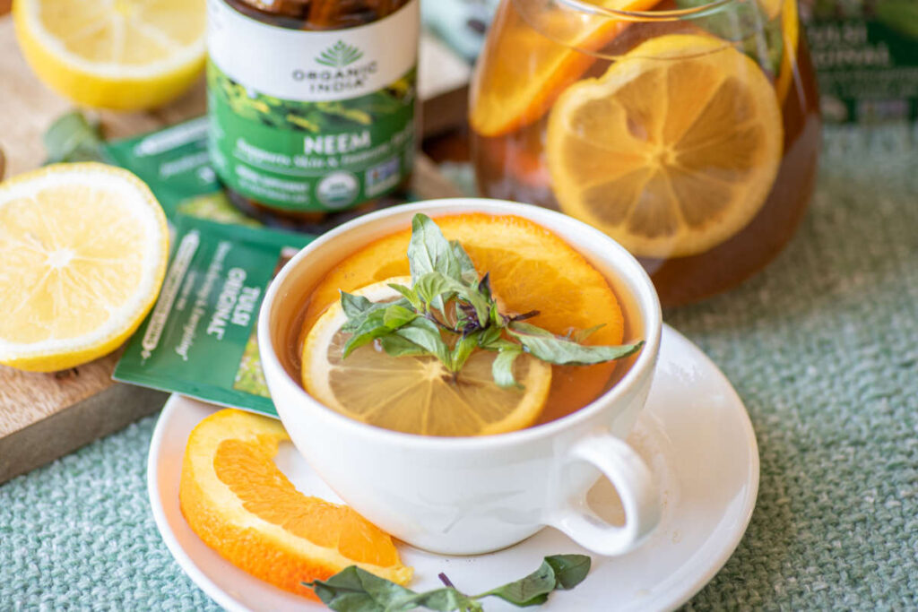 Immunity elixir featuring neem and tulsi in a teacup on a green tablecloth