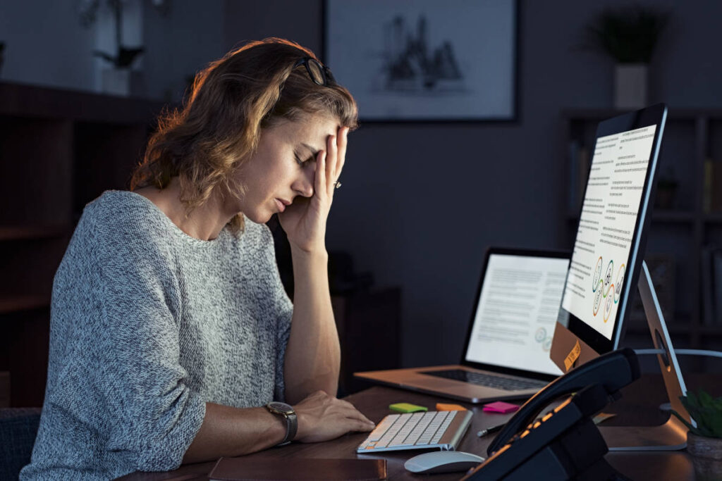 Woman working late at night on her computer, understanding work from home burnout