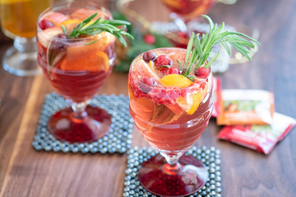 Winter mocktail spiced tea sangria with Tulsi Cinnamon Rose in a glass with fresh fruit and rosemary.